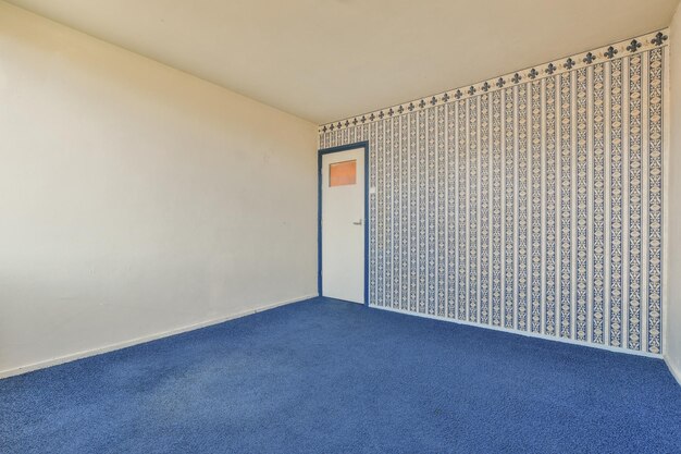 Foto een lege kamer met een blauw tapijt en een deur