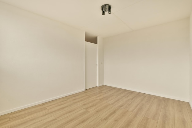 Een lege kamer met houten vloeren en witte muren