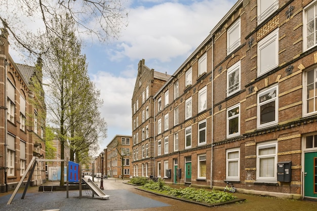 Een lege straat midden in amsterdam met aan weerszijden bebouwing en groene deuren naar andere wijken