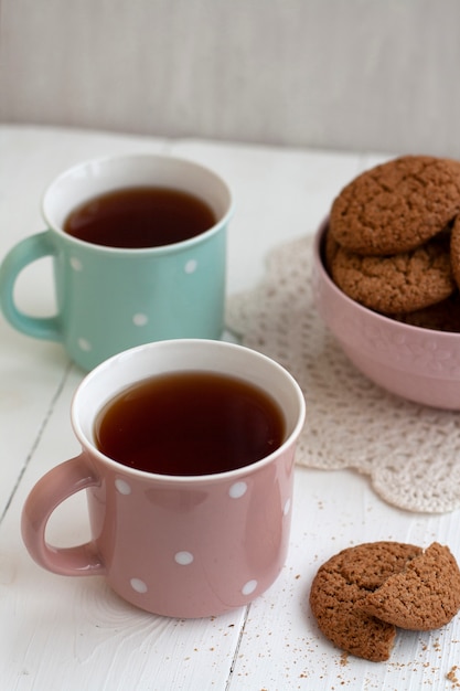 Een lekker tussendoortje: twee kopjes thee en een bakje koekjes.