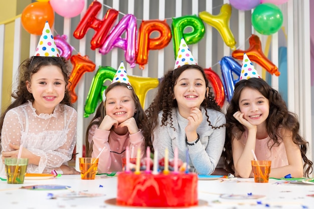 Een leuk verjaardagsfeestje voor kinderen in een versierde kamer Verjaardagstaart op de voorgrond
