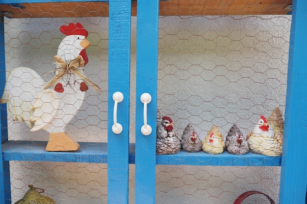 Een levendige en kleurrijke tentoonstelling van charmante kipfiguren in een blauwe kast