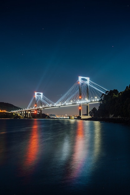 Een lichtgevende brug die 's nachts in het water reflecteert