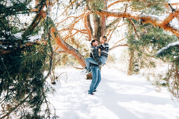 Een liefdevol jong stel rust in de bergen in een besneeuwd bos. concept gezamenlijke rust