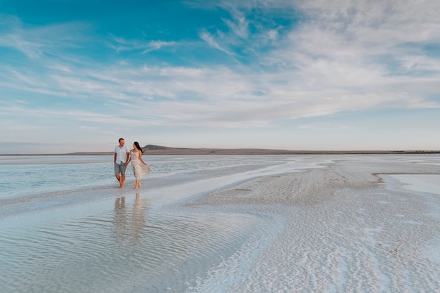 Foto een liefdevol stel loopt langs de kust.