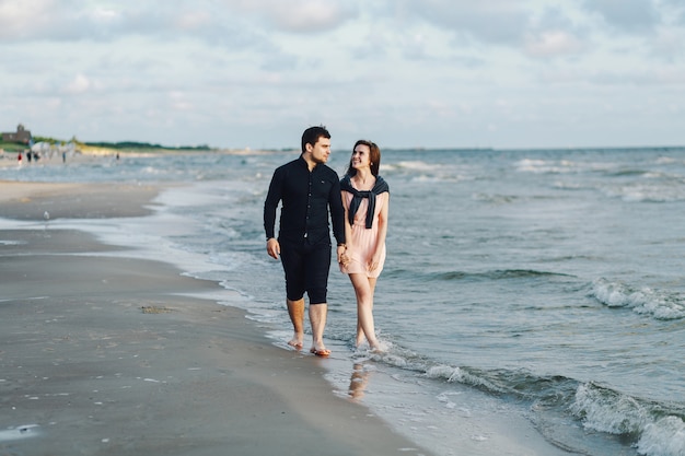 Een liefdevol stel slentert 's avonds langs de kust