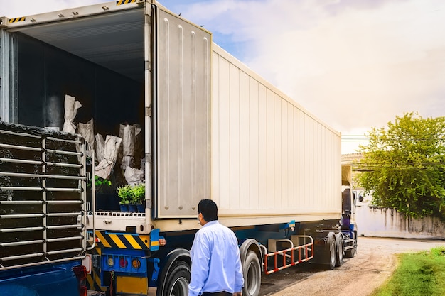 Een logistiek manager inspecteert het laden van goederen naar een containervrachtwagen voor distributie