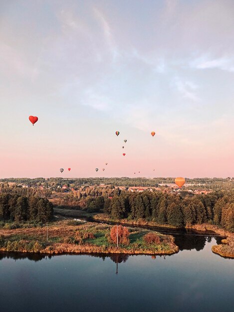 Foto een luchtballon vliegt over het water tegen de hemel tijdens de zonsondergang