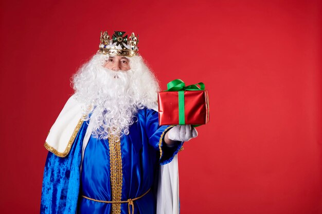 Foto een magische koning met een cadeau op een rode achtergrond