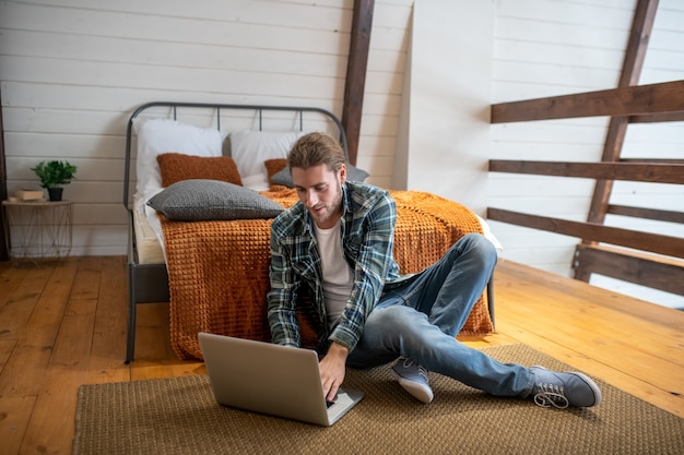 Een man aan het werk met een computer bij zijn bed