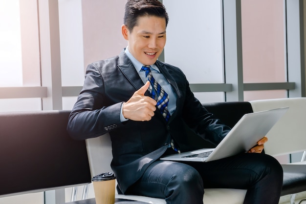 Een man aan het werk met een notebook Koffie drinken Zittend in een stoel