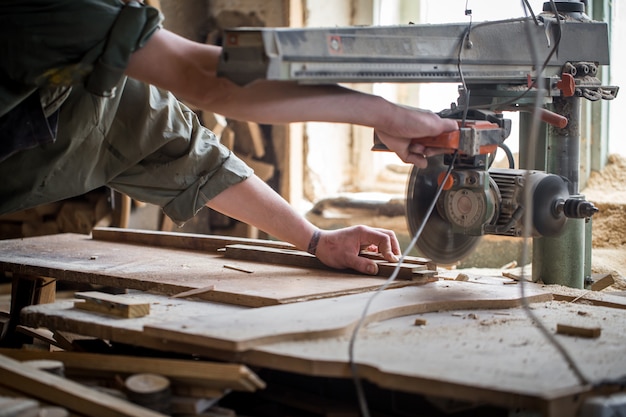 een man aan het werk met houtproduct op de machine