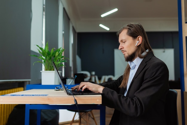 Een man aan het werk op een laptop op kantoor