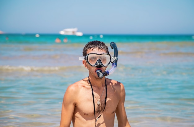 Een man aan zee in vinnen en masker.