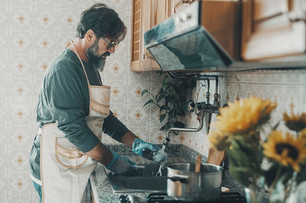 Een man afwassen thuis in de keuken na de lunch man helpt vrouw om huis schoon te maken Huishoudelijke schoonmaakroutine binnenshuis Concept van mensen die alleen wonen en huishoudelijk werk