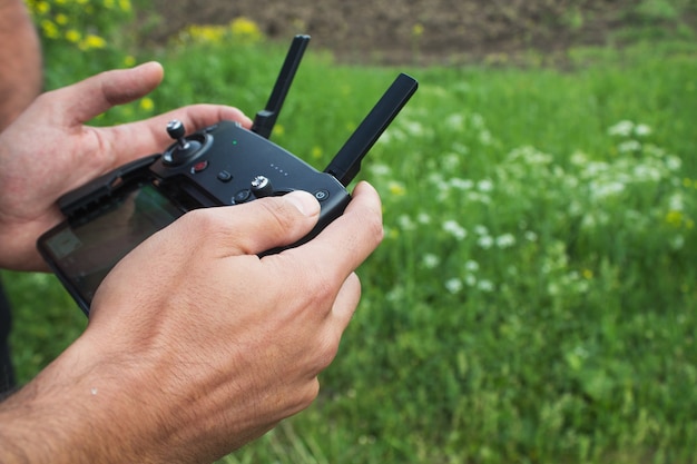 Foto een man bedient overdag de afstandsbediening van de drone