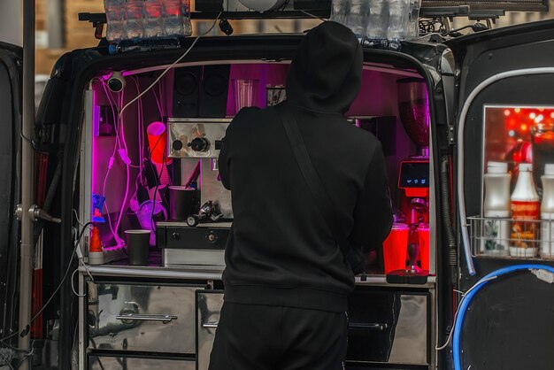 een man bereidt warme dranken, koffie, thee in een speciaal ingerichte coffeeshop in een auto op wielen