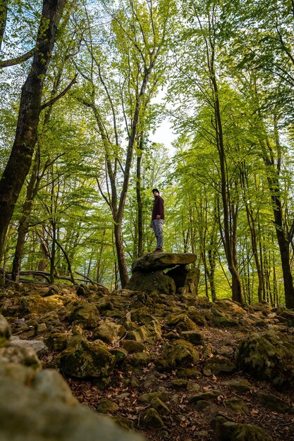 Een man bovenop de Aitzetako Txabala Dolmen in het Baskenland Errenteria Gipuzkoa verticale foto