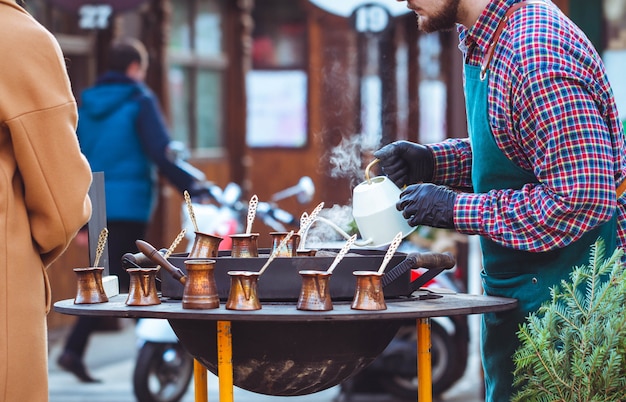 Een man brouwt koffie op straat.