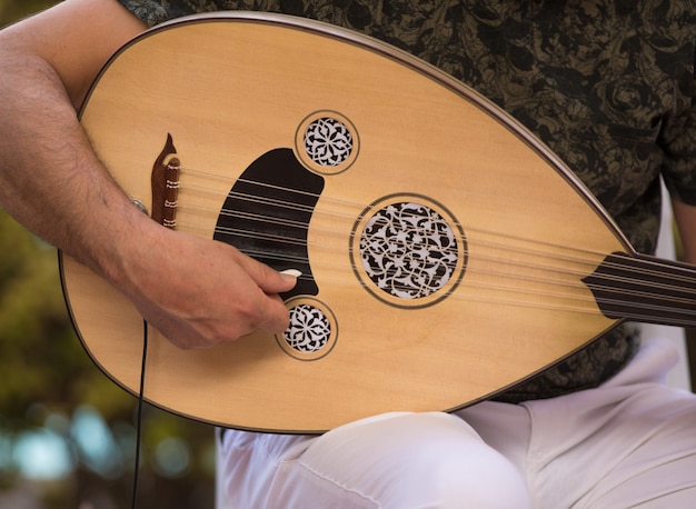 Foto een man die een arabisch muziekinstrument bespeelt