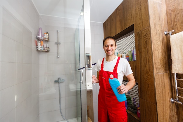 Foto een man die een doucheglas schoonmaakt