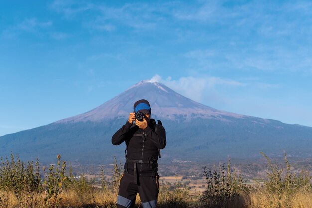 Een man die een foto maakt van de vulkaan popocatepetl