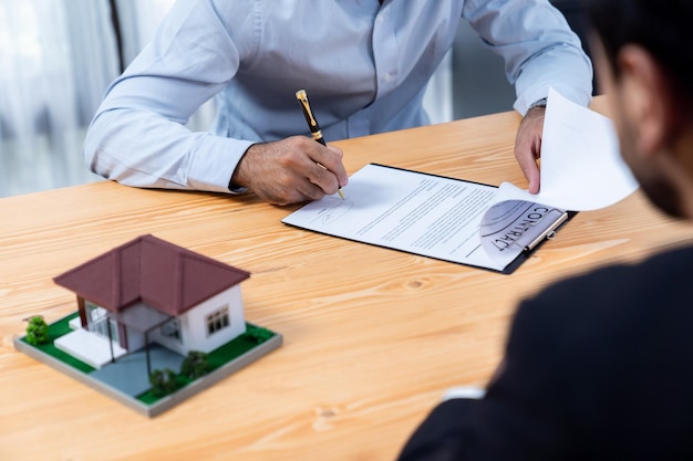 Een man die een huis signeert met een pen naast hem