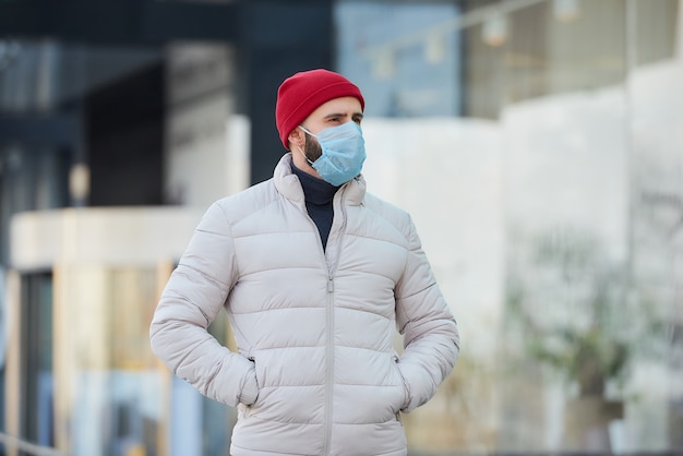 Een man die een medisch gezichtsmasker draagt om het verspreide coronavirus te voorkomen (COVID-19).