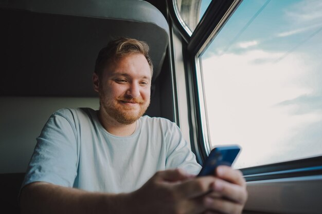 Een man die een smartphone gebruikt terwijl hij met de trein reist