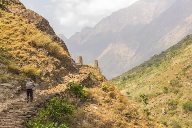 Een man die langs een bergpad loopt in de vorm van trappen in de regio Manaslu