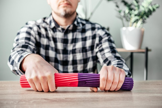 Een man die polsoefeningen doet met theraband flexbar