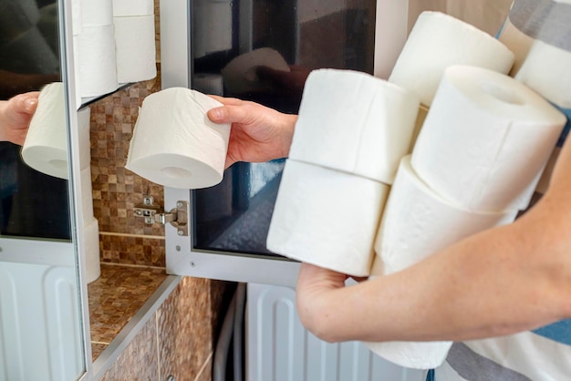 Een man die thuis toiletpapier opslaat Crisis product ontbreekt concept