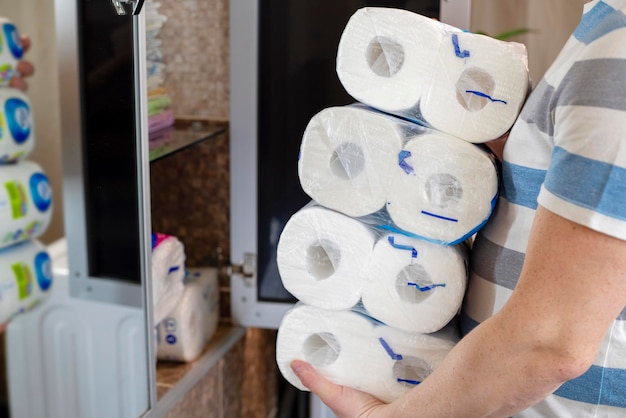 Een man die thuis toiletpapier opslaat.