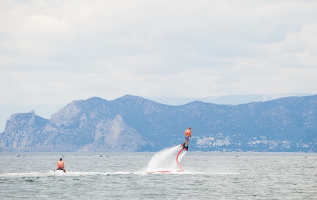 Een man die zich bezighoudt met flyboarden op de oceaan.