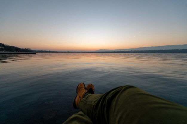 Foto een man die zich koelt aan de waterkant van het meer van genève.