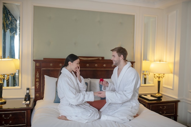 Een man doet een voorstel aan een vrouw in een hotel