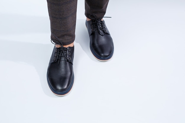 Een man draagt klassieke zwarte schoenen gemaakt van natuurlijk leer aan kant, schoenen voor mannen in zakelijke stijl. Hoge kwaliteit foto