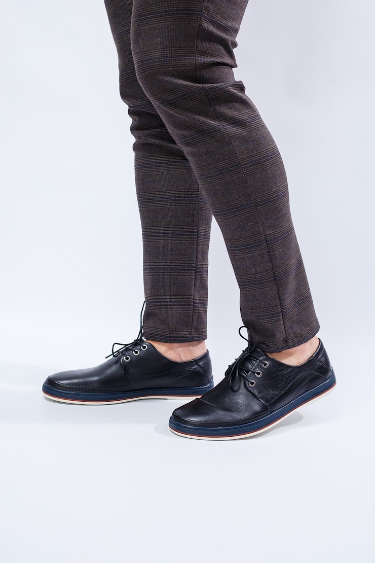 Een man draagt klassieke zwarte schoenen gemaakt van natuurlijk leer aan kant, schoenen voor mannen in zakelijke stijl
