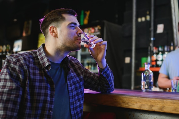 Een man drinkt wodka in een bar