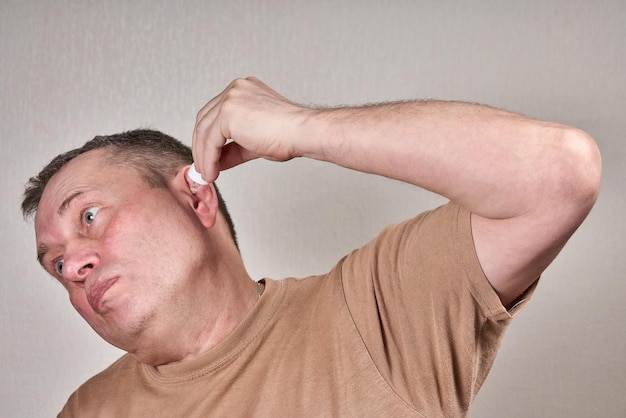 Foto een man druppelt medicijnen in zijn oor met een kleine pipet uit een apotheekfles