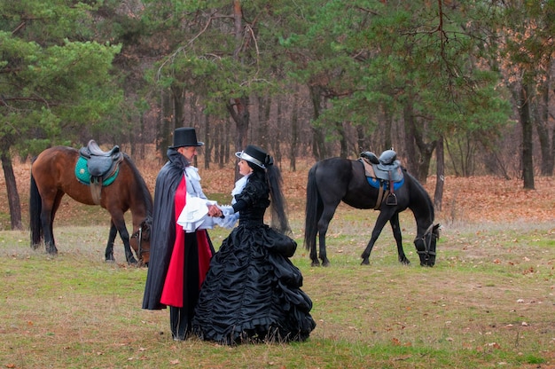 Een man, een vrouw in oude kleren en paarden.