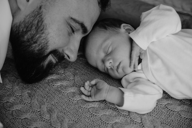 een man en een baby slapen op een tapijt