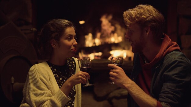 Een man en een vrouw drinken uit een glas wijn.