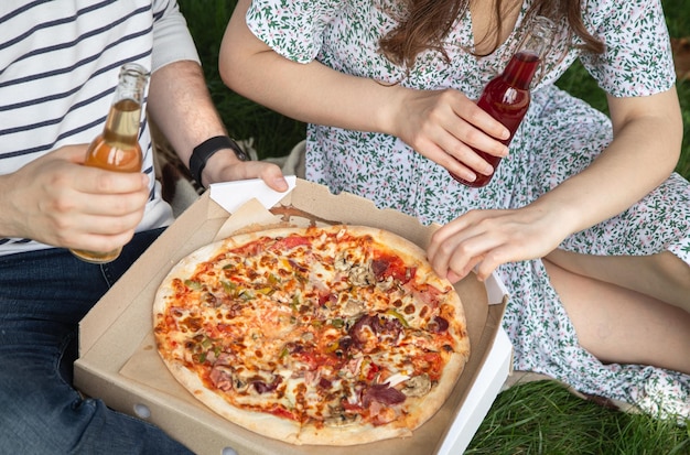 Een man en een vrouw eten pizza bij een picknickclose-up