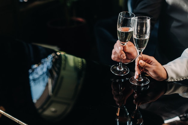 Een man en een vrouw houden champagneglazen in hun handenclose-up.