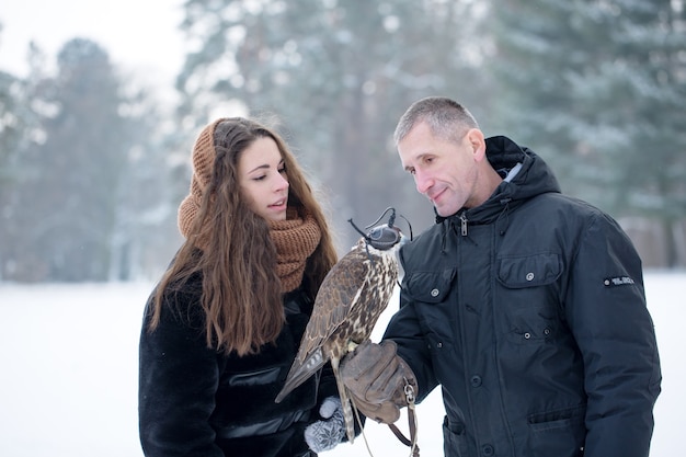 Een man en een vrouw houden een valk vast