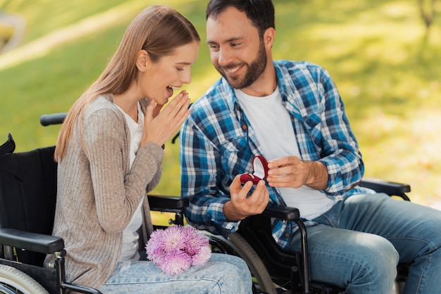 Een man en een vrouw in een rolstoel ontmoetten elkaar in het park.