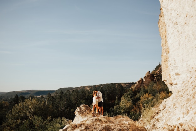 Een man en een vrouw knuffelen elkaar op de berg