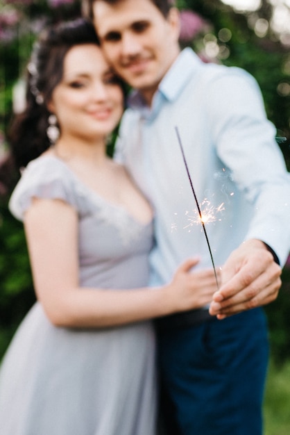 Een man en een vrouw lopen in de lentetuin van seringen voor de huwelijksceremonie