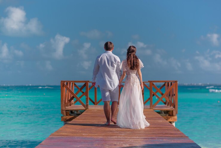 Foto een man en een vrouw lopen op de pier bij de zee.